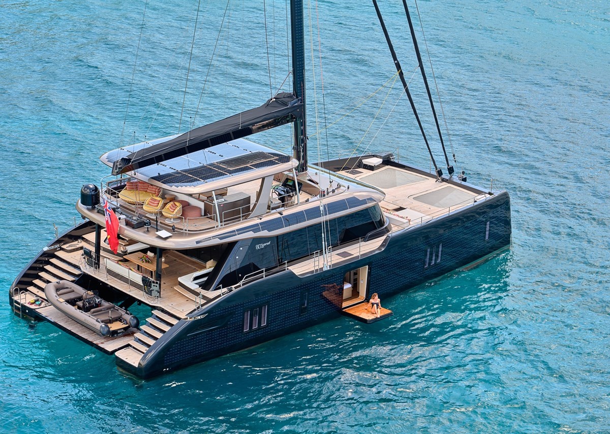 Aerial view of the Sunreef 80 catamaran at anchor in clear turquoise water