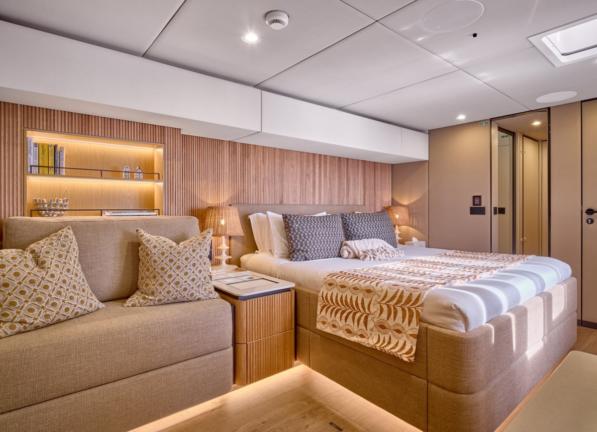 Owner's cabin of the Sunreef 80 with king bed and warm wood panelling
